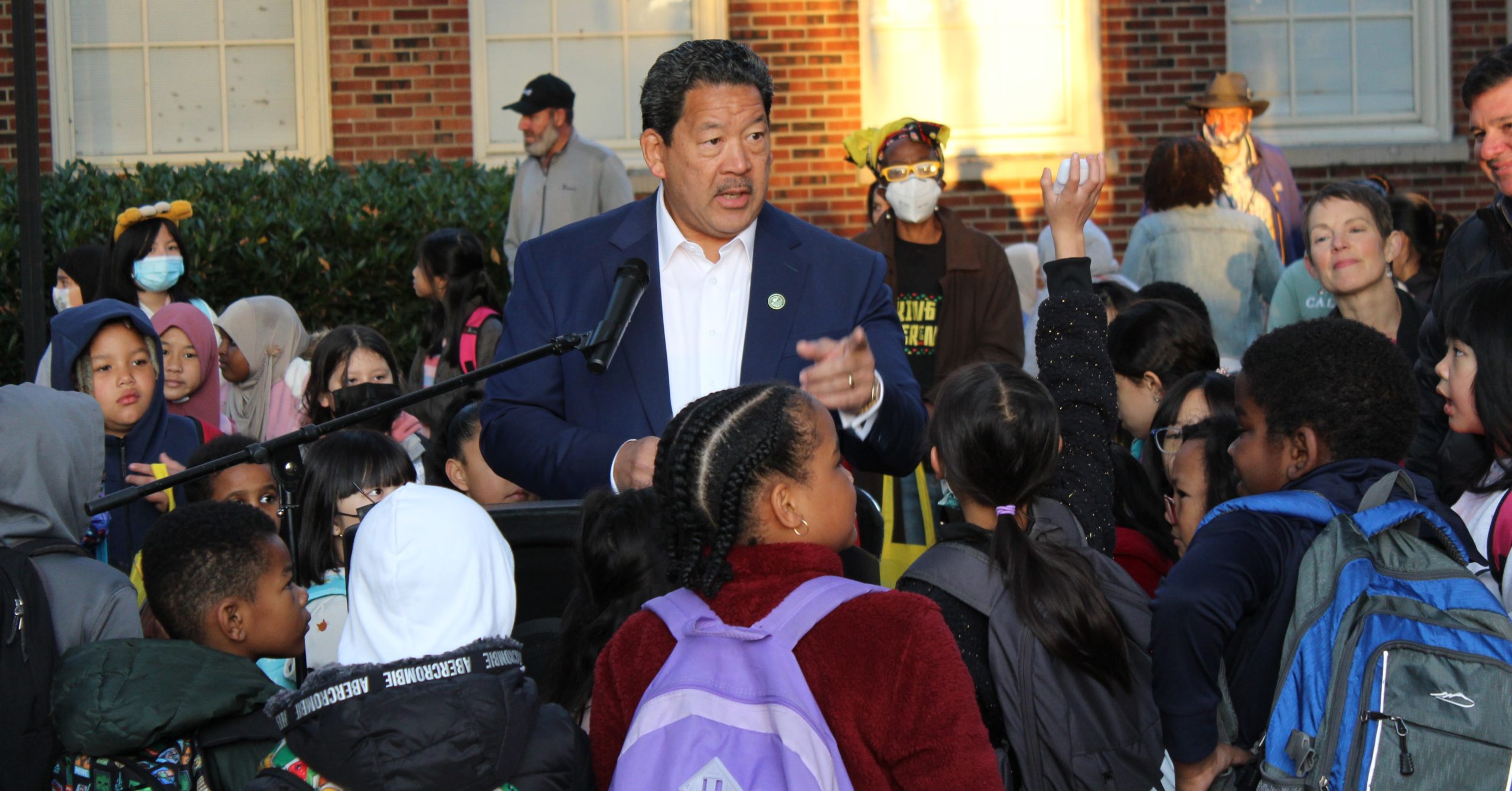 Mayor Harrell taking questions from young students outside school