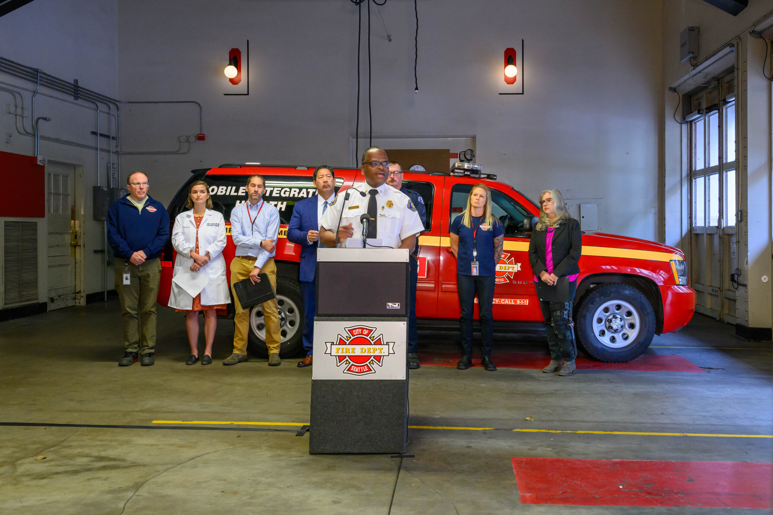 Seattle Fire Chief Harold Scoggins speaks in front of a Health 99 vehicle.