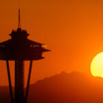 Space Needle and mountains at sunset