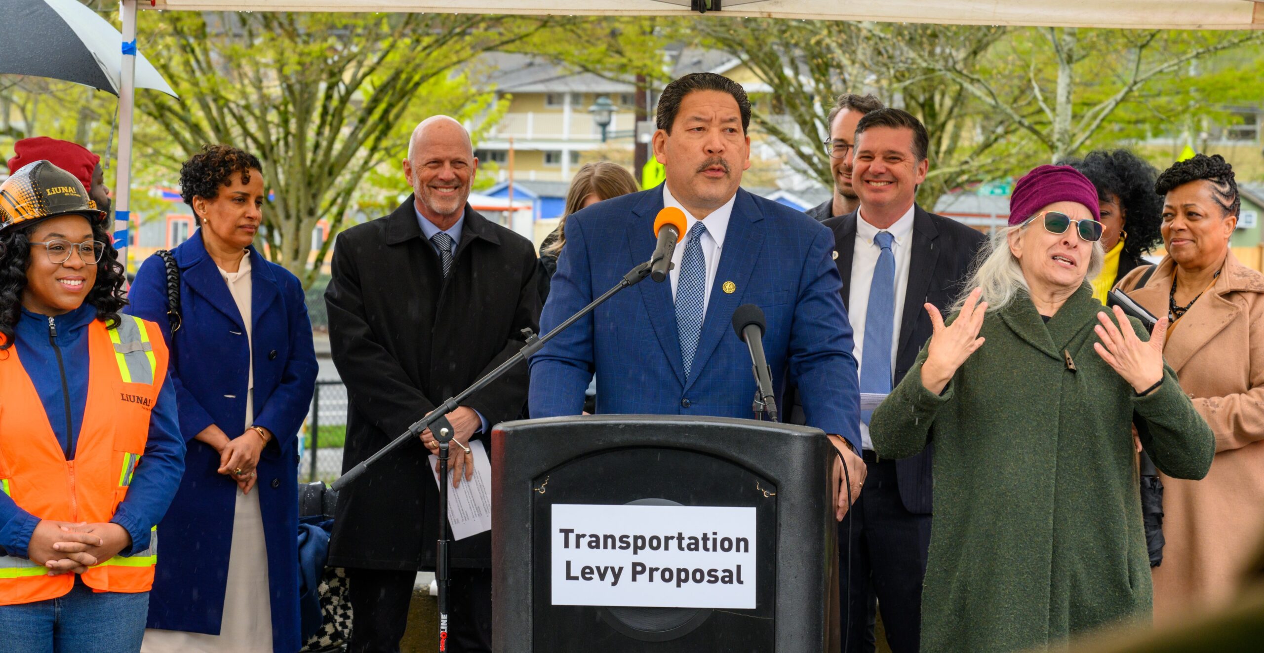Mayor Harrell at podium for Transportation Levy with local transportation leaders in background