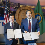 Mayor Harrell and KOSME President Seogjin Kang hold up the signed MOUs