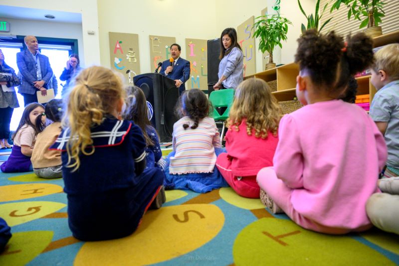 Students at a preschool listen to Mayor Harrell