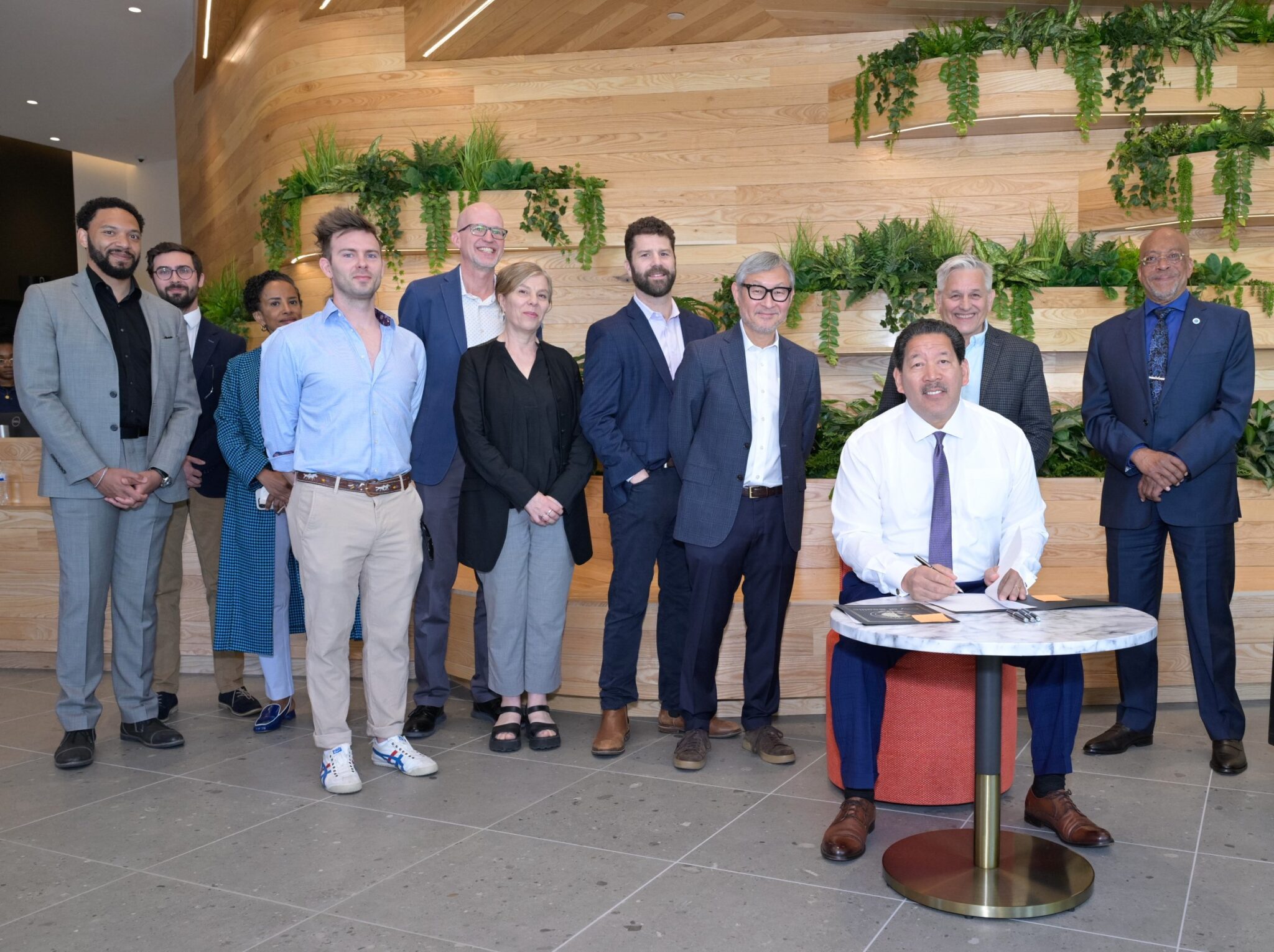 Mayor Harrell signs Downtown Activation Plan legislation with leaders and community stakeholders behind him.
