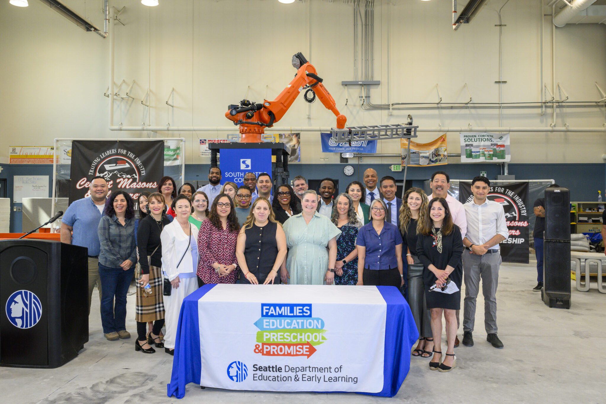 Mayor Harrell and education eladers smile at the Georgetown campus in a concrete mason classroom after signing the FEPP levy legislation.