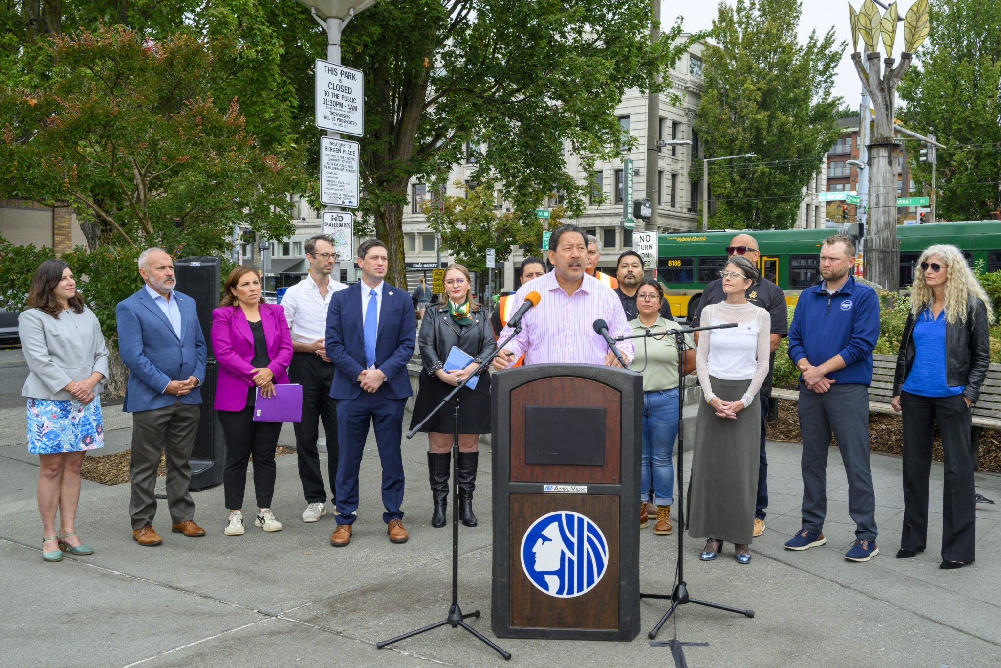 Mayor Harrell speaking at podium in Ballard with local elected, transportation, and labor leaders